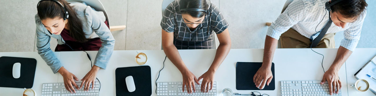 overhead view of people working on desk in workplace
