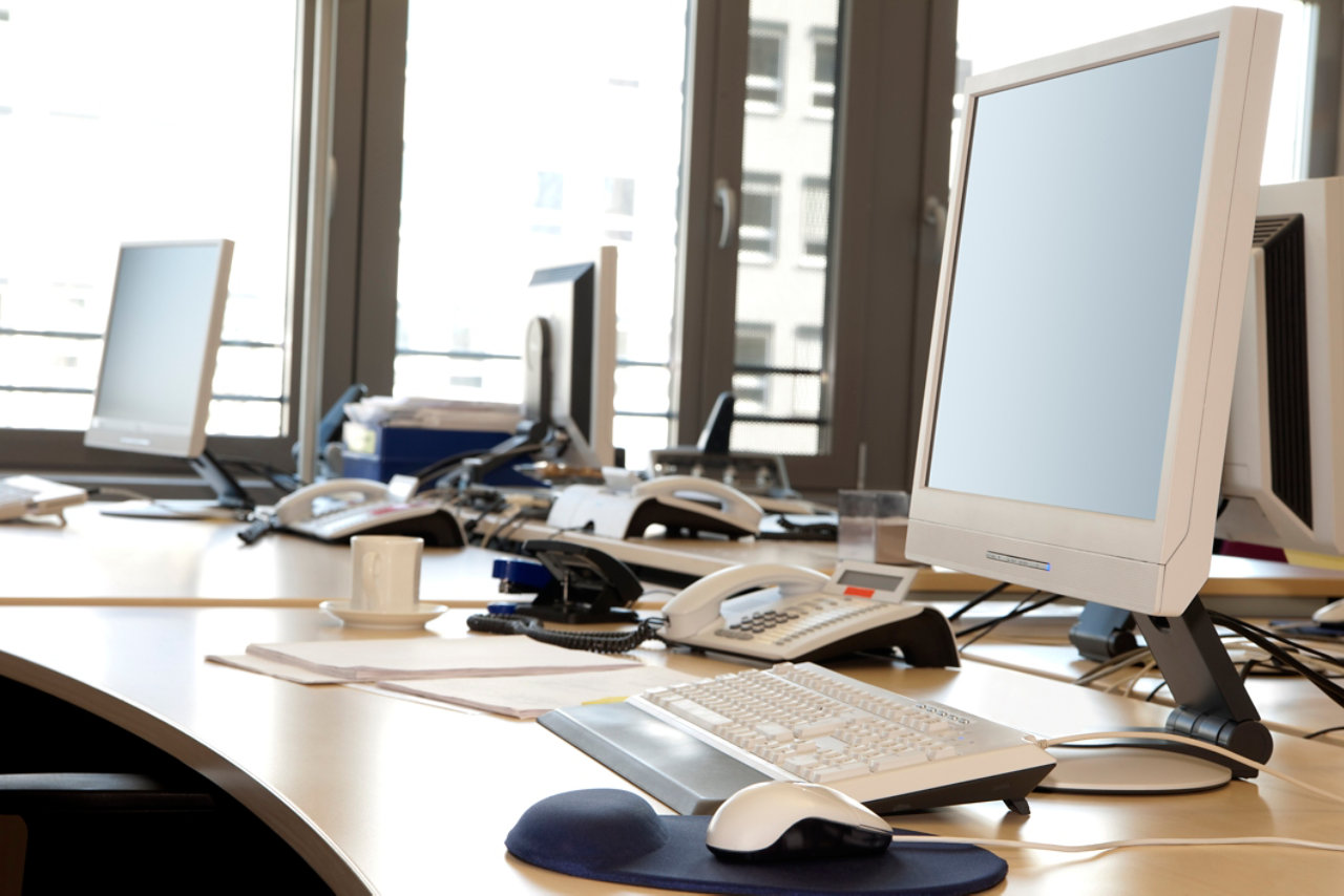 Office desk with screens and phones