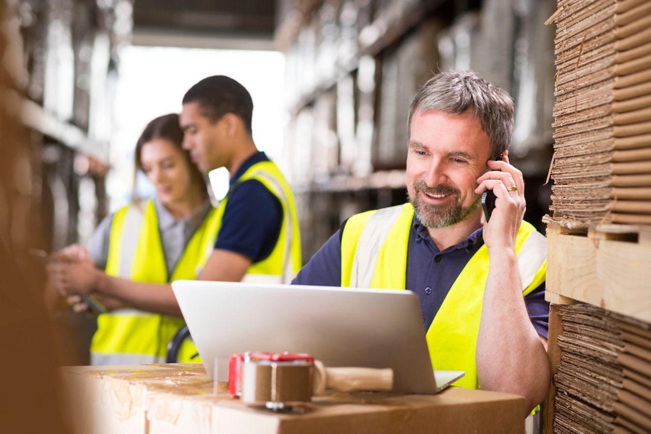 man using phone in warehouse