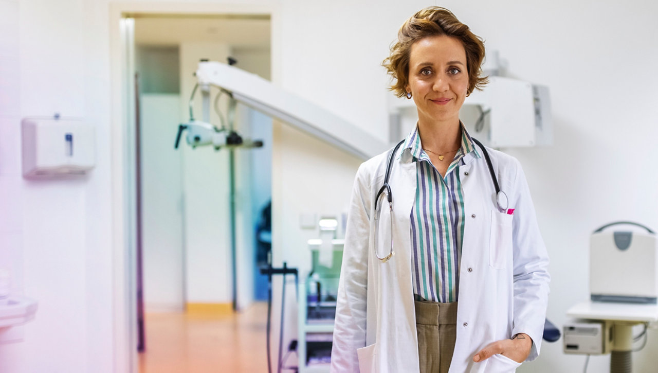 Doctor standing in a room and smiling