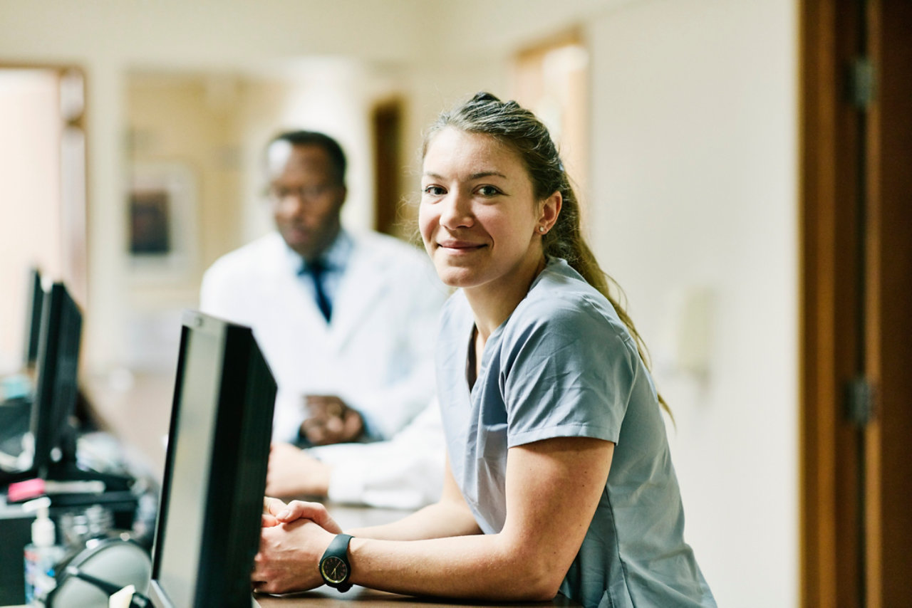 Smiling nurse sittting at her desk