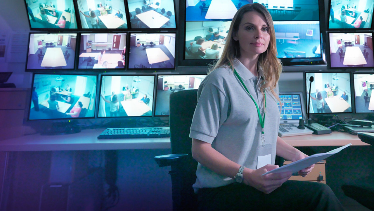 Woman sitting by some screens