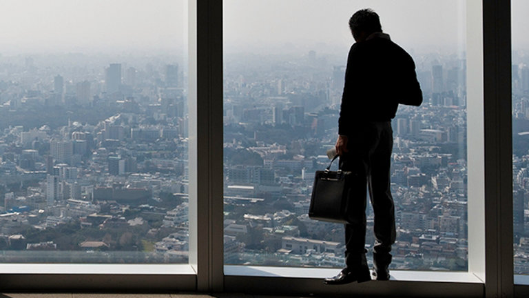employee looking out an office block window