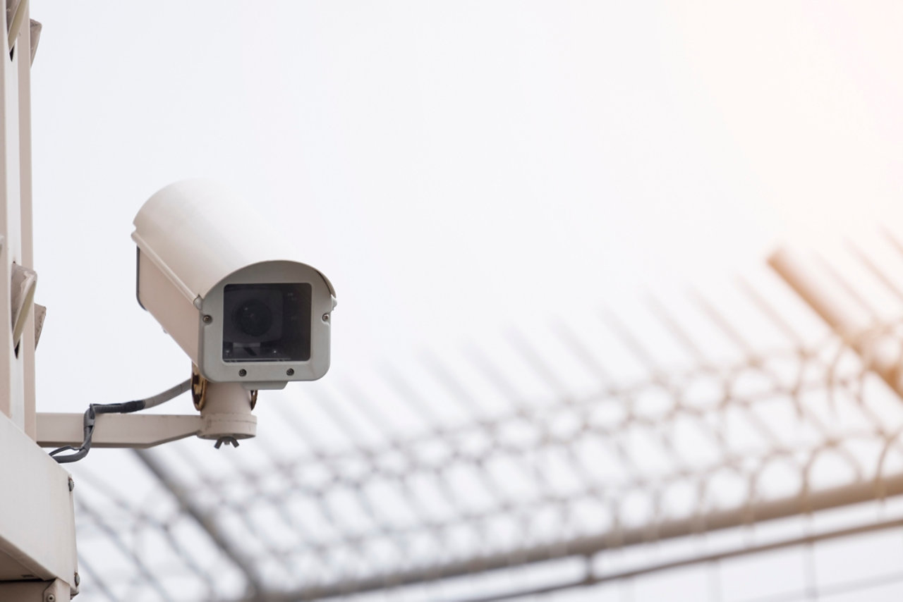 A CCTV camera on the side of a structure looking down