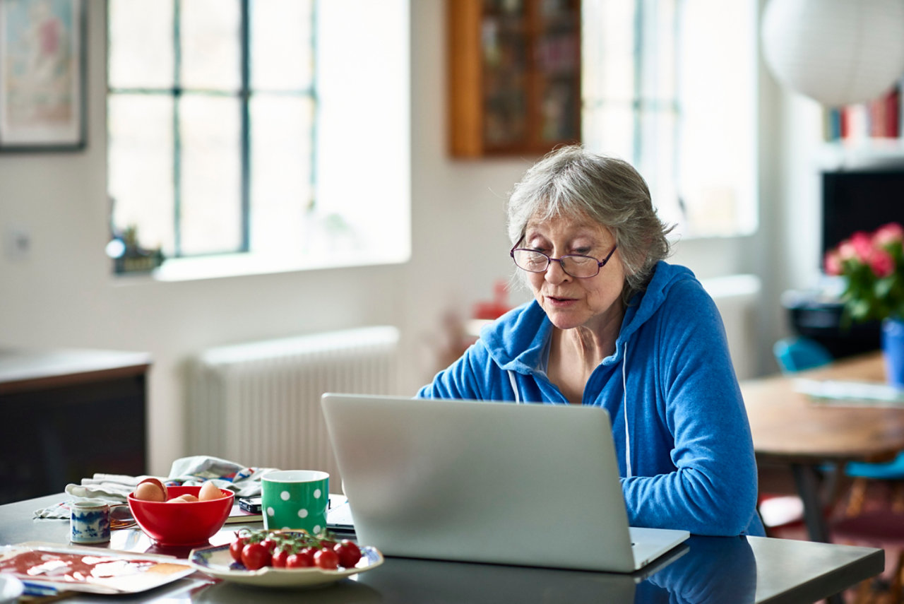 Senior woman wearing glasses using laptop