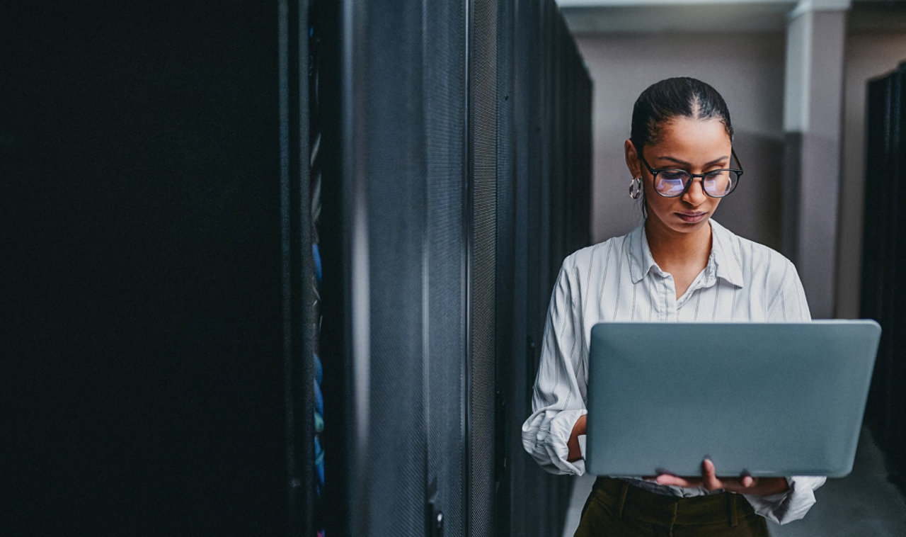 person walking with laptop in data centre