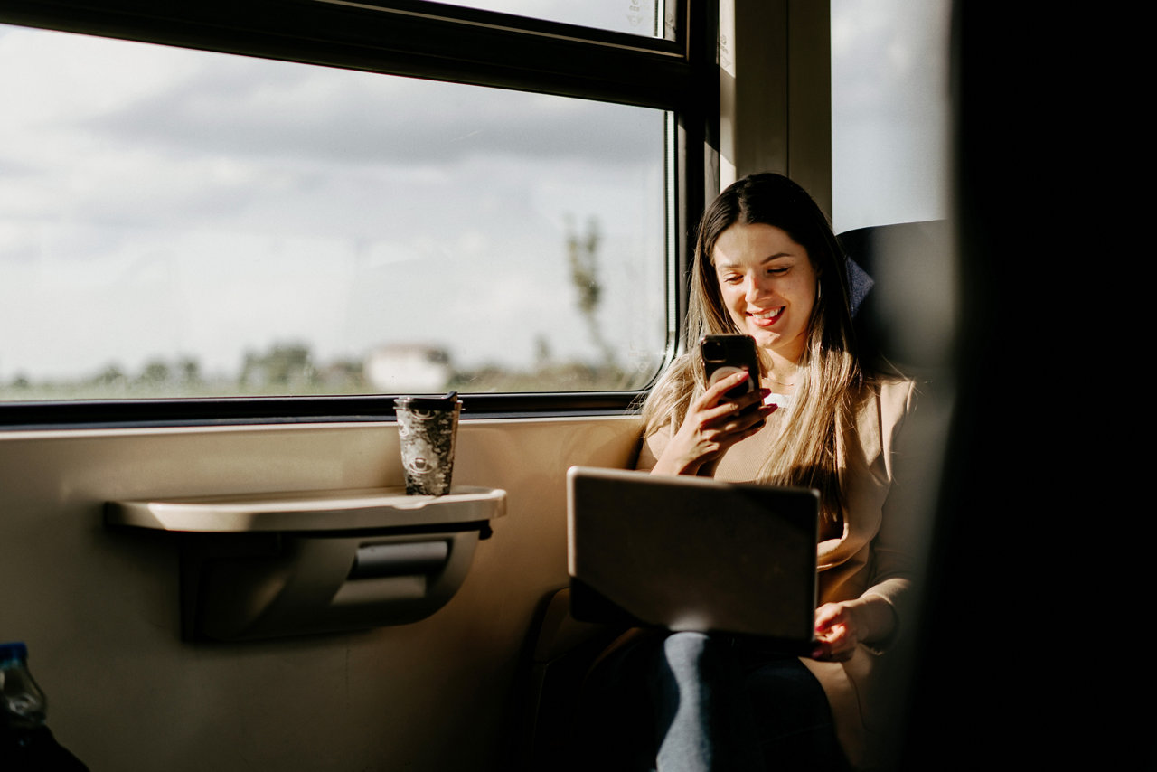 person on the train with laptop and phone