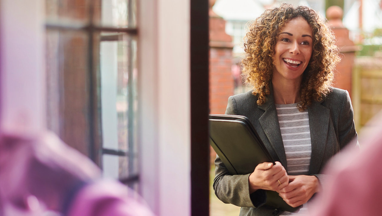 Young woman speaking to customer at the door