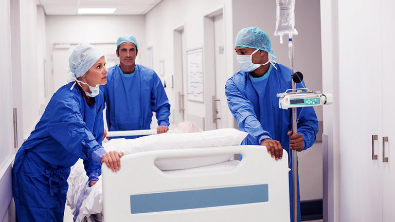 surgery team pushing patient