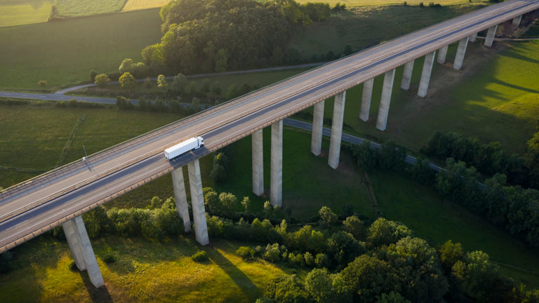truck driving over high bridge