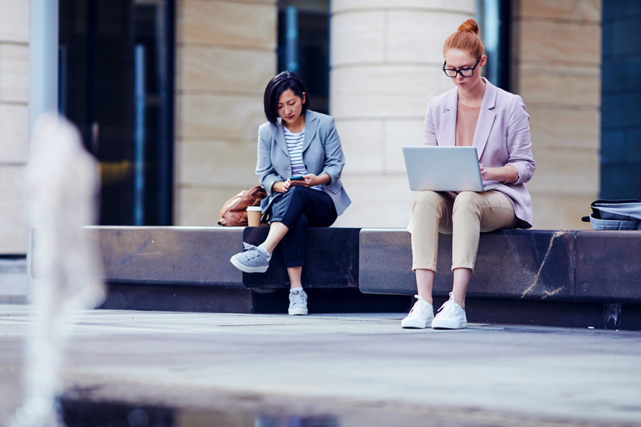 two ladies working on their devices