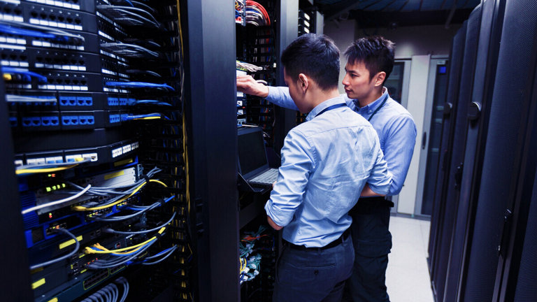 two men working in server room