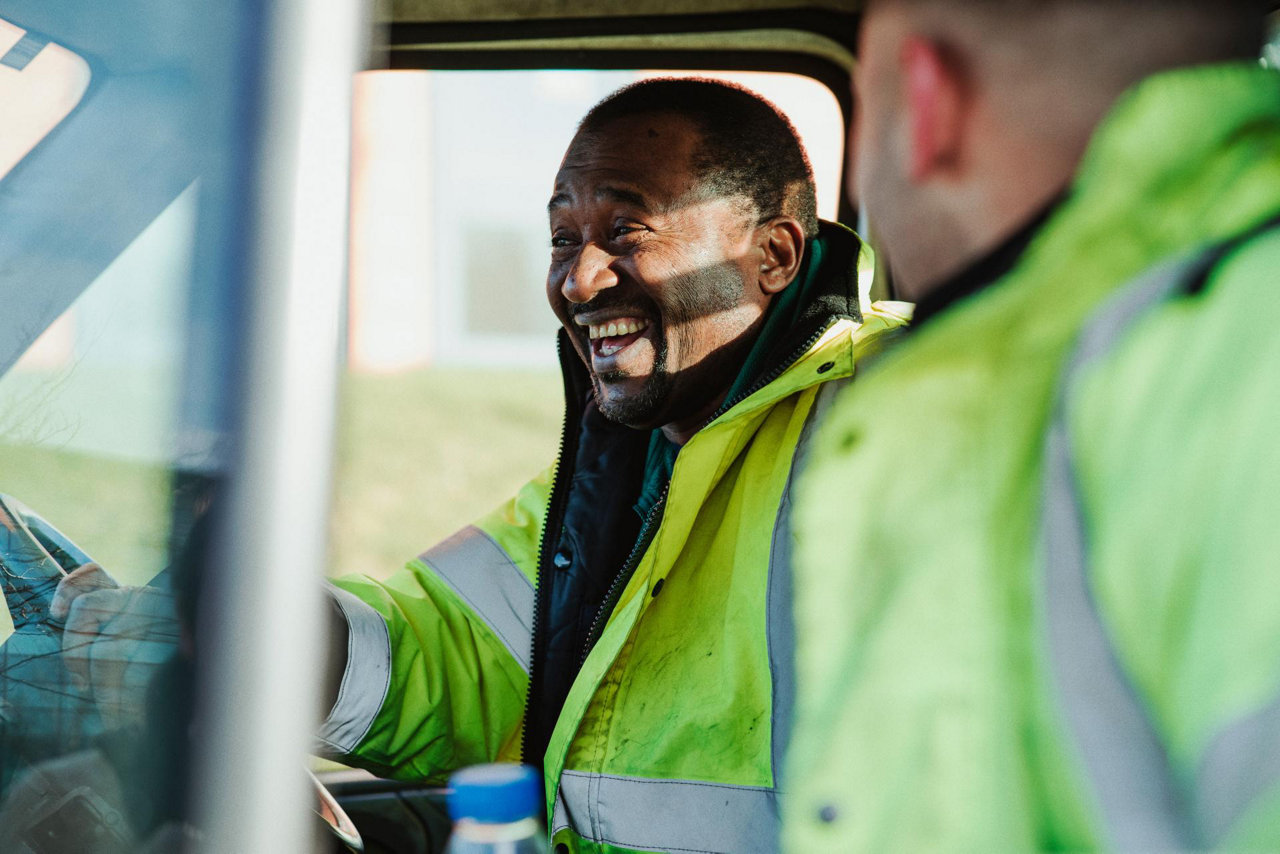 two people in high vis jackets driving a vehicle