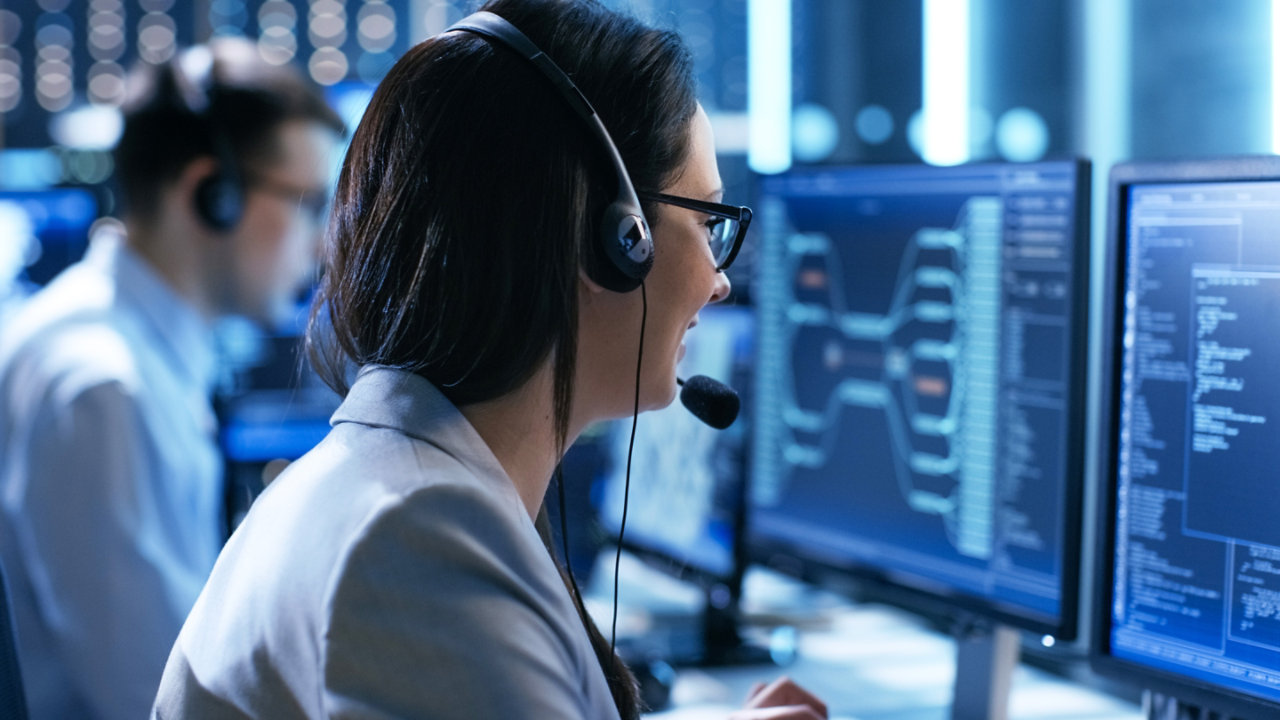 woman with headset looking at screen