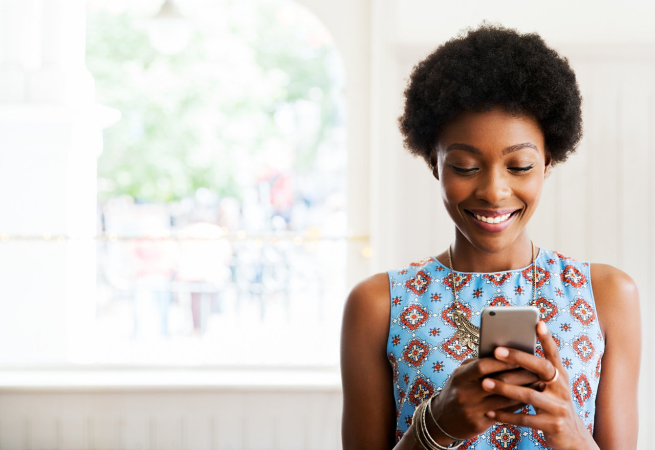 Woman smiling using smartphone