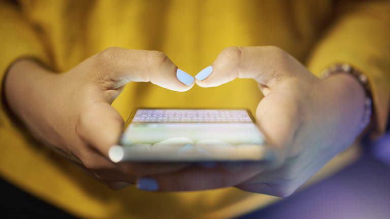 Woman typing on mobile phone