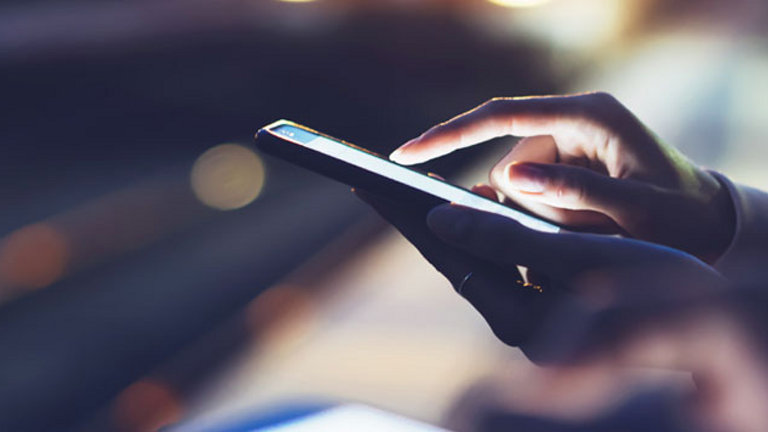 woman using mobile phone at night blurred background