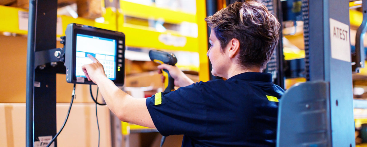 Woman using scanner in forklift truck