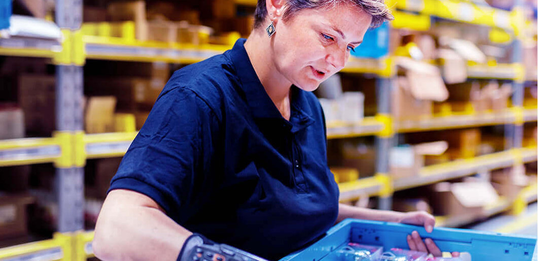 Woman using scanner in warehouse