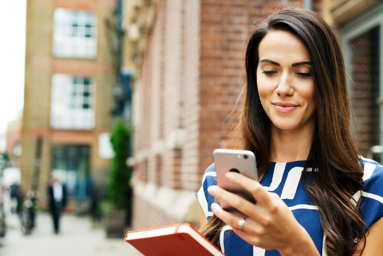 Woman using smart phone on street