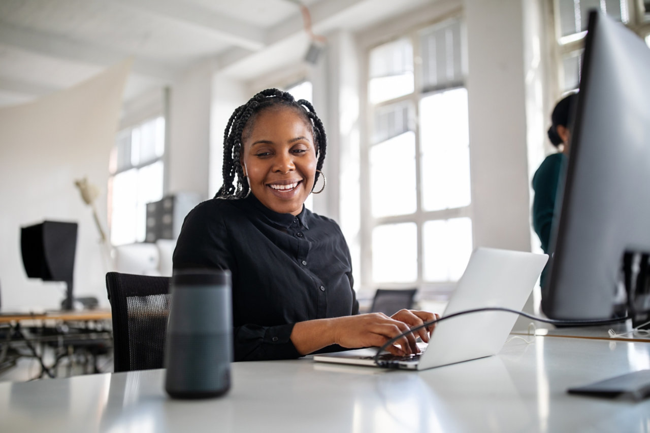 Woman using virtual assistant on office desk