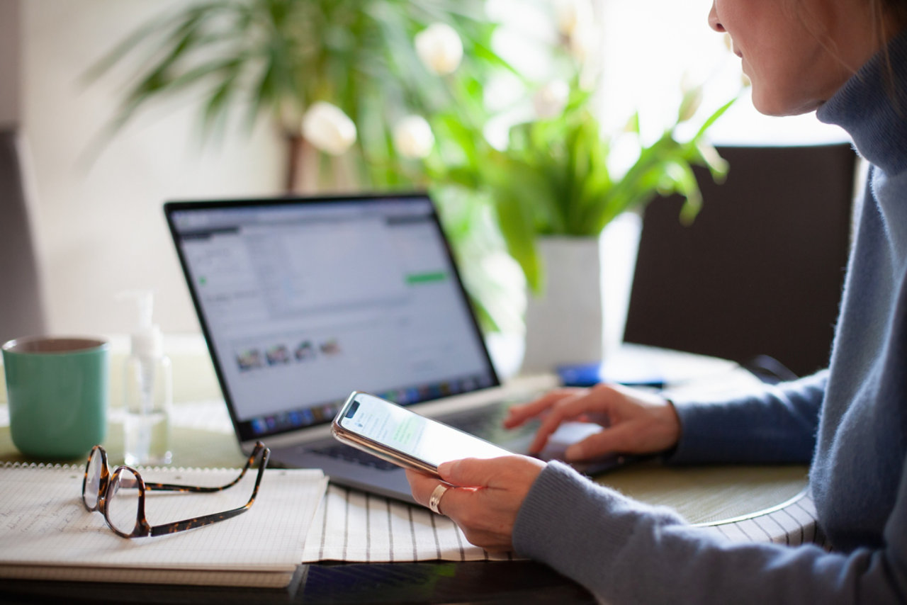 woman working from home using laptop on mobile phone