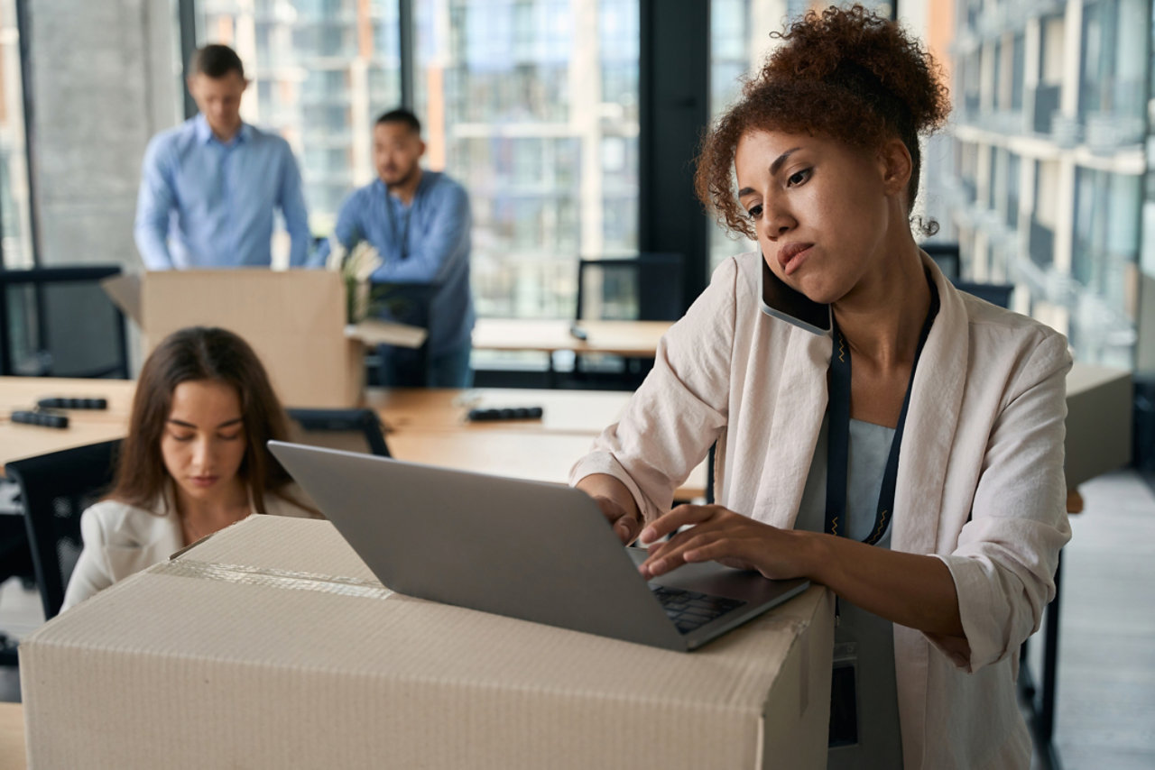 Woman working on a laptop on top of a box