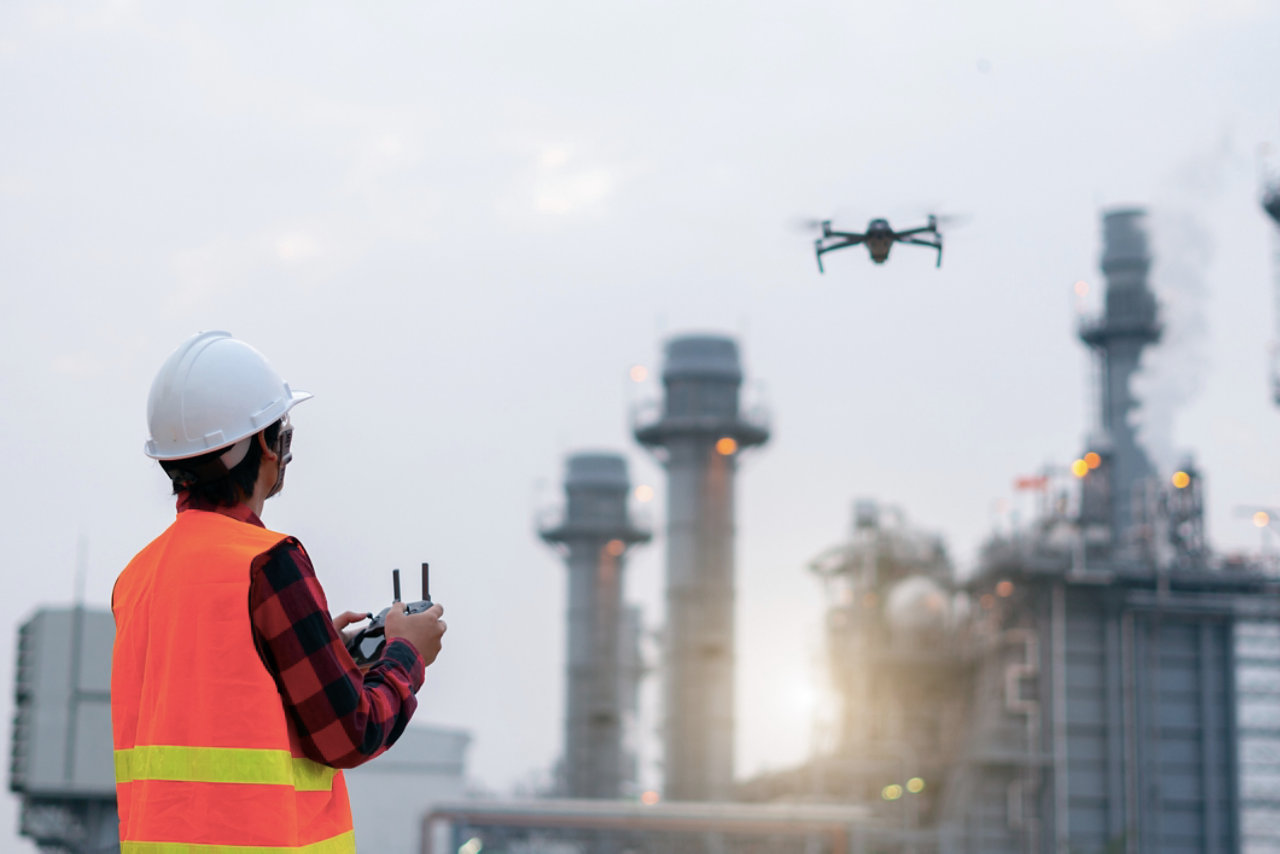young engineer piloting drone at power plant