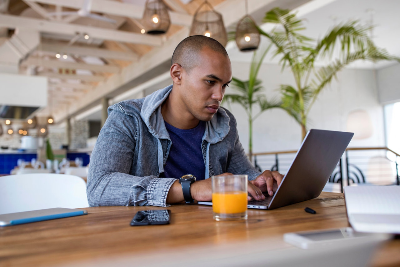 Young man using laptop in a cafe