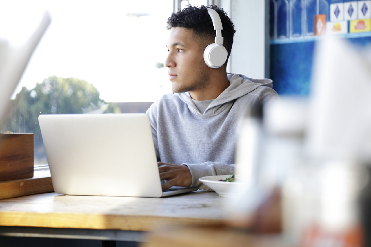 Young man wearing headphones using a laptop