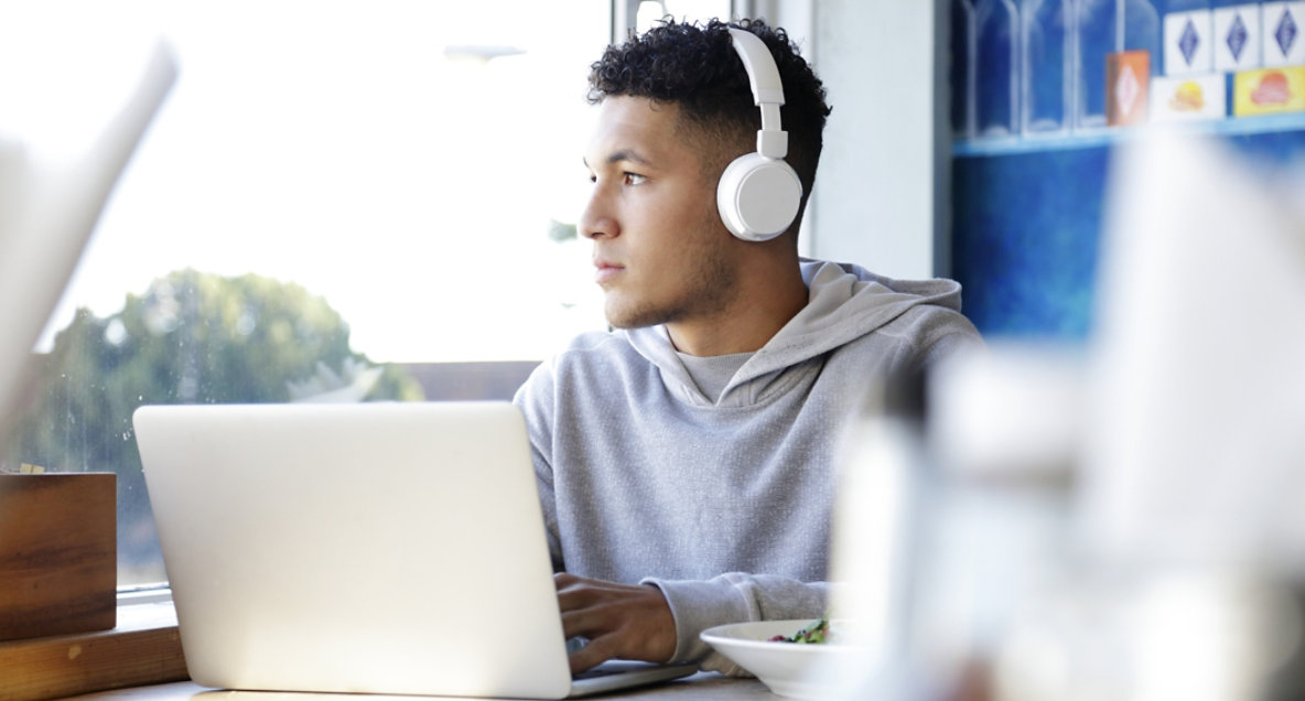 young-man-wearing-headphones-using-a-laptop