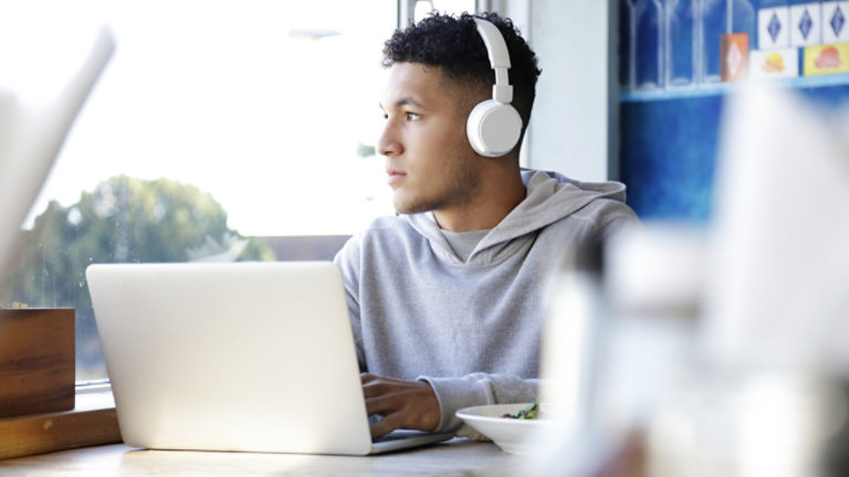 Young man wearing headphones using a laptop